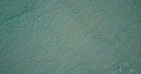 Daytime flying copy space shot of a white paradise beach and aqua turquoise water background 