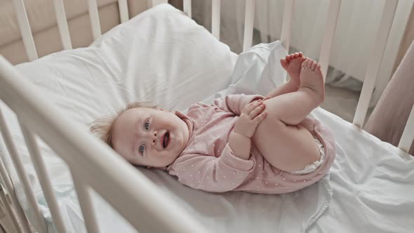 Happy Newborn Girl in Crib