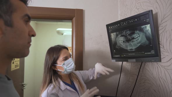 Dentist gives information to his patient via x-ray.