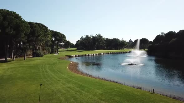 Golfer strikes ball in man back shot while drone follows it