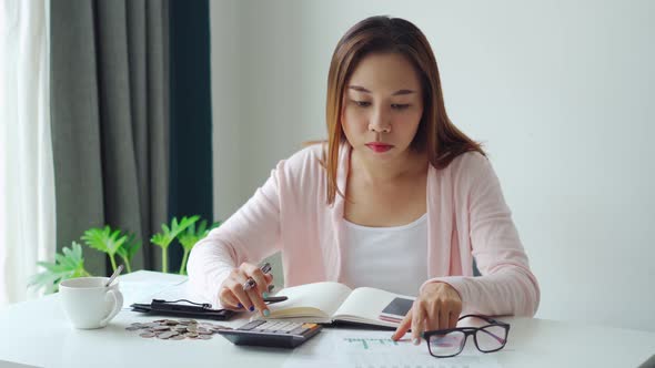 Stressed young woman calculating monthly home expenses