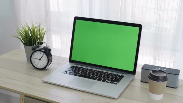 Slide shot, Chroma key green screen of laptop computer set on working space in home office.