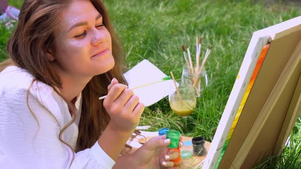 Young Attractive Woman Artist Paints on Nature