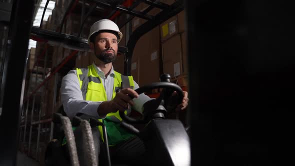 Focused Forklift Driver During Work in Storage