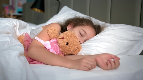 Sixyearold Girl Sleeps Sweetly in His Crib and Smiles in His Sleep