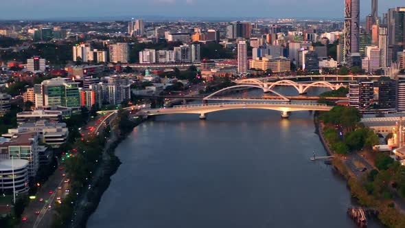 Brisbane River, Bridge, Traffic, And Downtown Skyline At Sunset In Queensland, Australia. - aerial