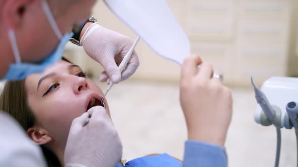 Male dentist treating woman's teeth