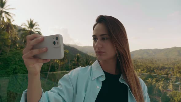 Happy Tourist is Pivoting in One Direction to Take a Panorama of the Topical Forest with Her