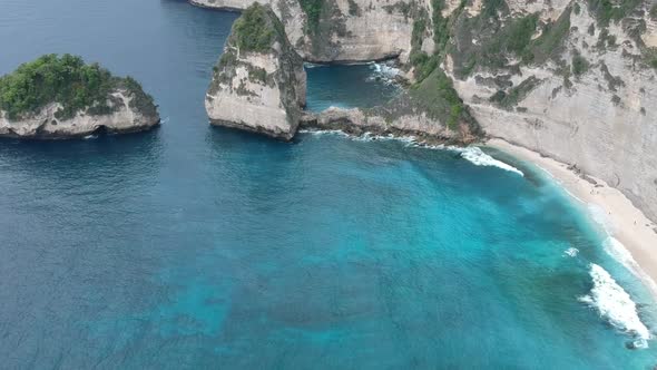 Aerial drone view of atuh beach and blue ocean waves In Nusa Penida, Bali, Indonesia.