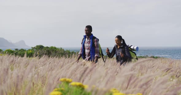 African american couple walking while trekking in the mountains