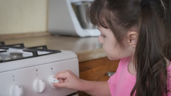 Dangerous act. A little girl turn the stove on. 