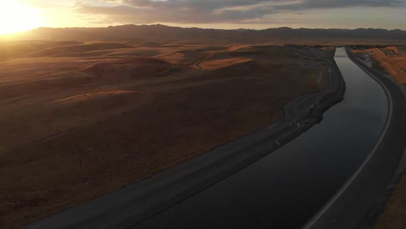 Left to right aerial near sundown over the aqueduct supply fresh water to Californian farms and peop