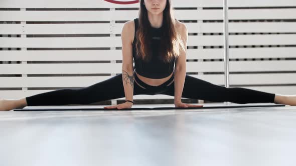 Fitness  a Young Woman Gymnast Sits in a Splits and Leaning Forward