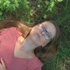 Woman enjoying summer day lying on a grass and dreaming in a forest park. - VideoHive Item for Sale