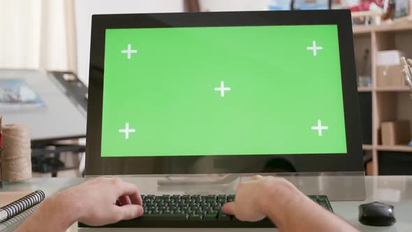 Male Hands Typing on a Keyboard in Front of a Green Screen