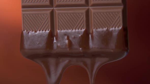 Chocolate Bar with Melted Dark Chocolate Dripping on a Brown Background