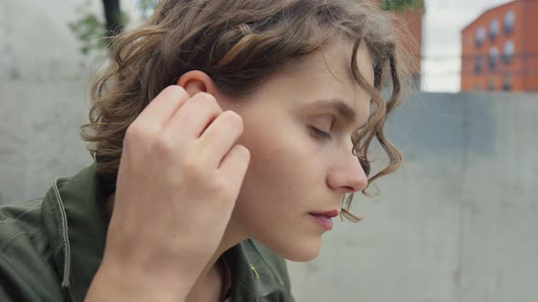 Young Authentic Woman Insert Ear Buds for Music