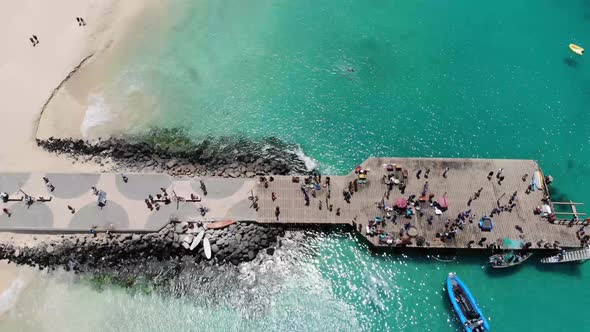 Aerial footage of the famous pier at Cape Verde, fishermen with fishermen's wives selling the fish