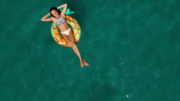 Aerial Top View of Calm Turquoise Sea Water and Beautiful Relaxed Woman Swimming on the Yellow