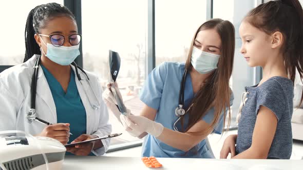 Two Female Doctors and Girl on Check Up