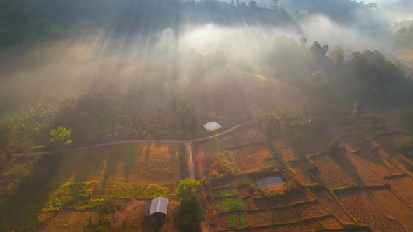 Aerial view over villages and barren fields in countryside during sunrise