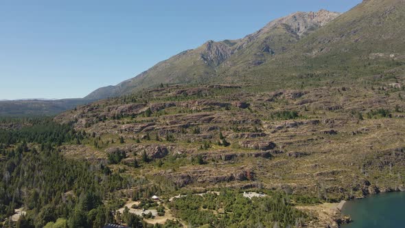 Aerial dolly in of Andean mountains surrounded by pine trees near Epuyen lake, Patagonia Argentina