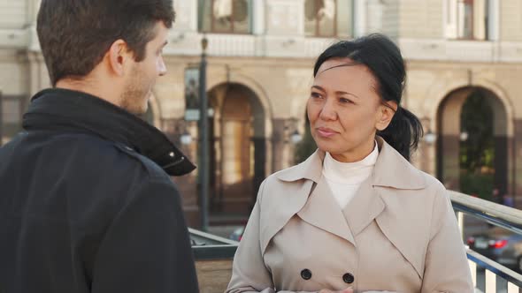 Cheerful Woman Is Talking with a Young Man