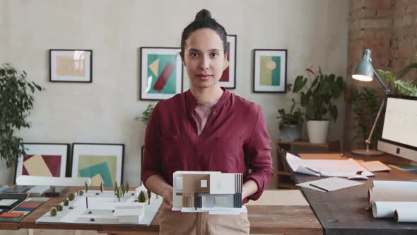 Portrait Of Female Architect With 3D House Layout