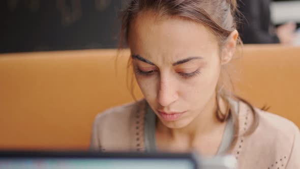 Pensive Woman Working Intently at Laptop