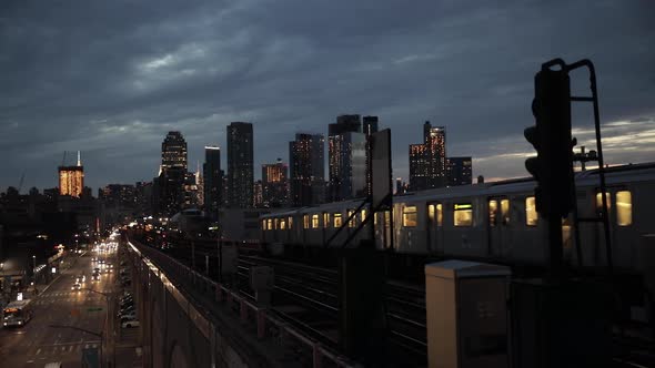 Night view of New York with metro train and cars on foreground and skyscraper