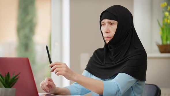 Mature Muslim Woman in Hijab Training Eyes Following Pen with Eyesight Rubbing Eyes