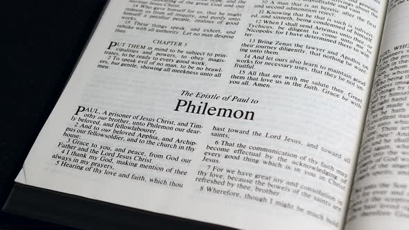Close Up Shot of  Bible Page Turning to the book of Philemon