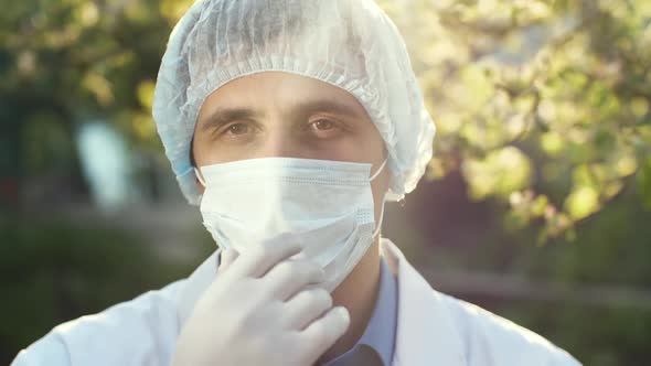 Physician Takes Off a Surgical Mask at the Sunset