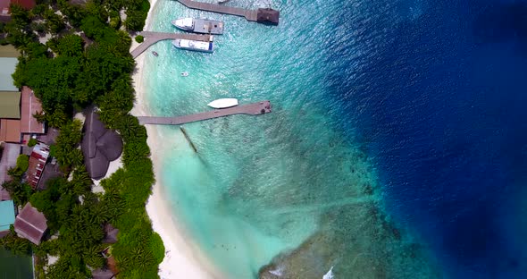 Wide angle above travel shot of a summer white paradise sand beach and aqua blue ocean background in