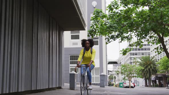 African american woman riding bicycle in street