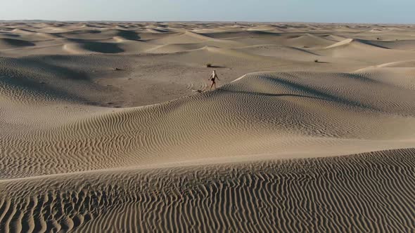 Great Sandy Desert UAE Woman with Blonde Hair is Walking on a Sand Dune