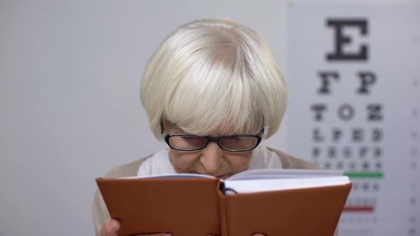 Retired Female in Spectacles Reading Book, Unhappy With Poor Vision, Problem