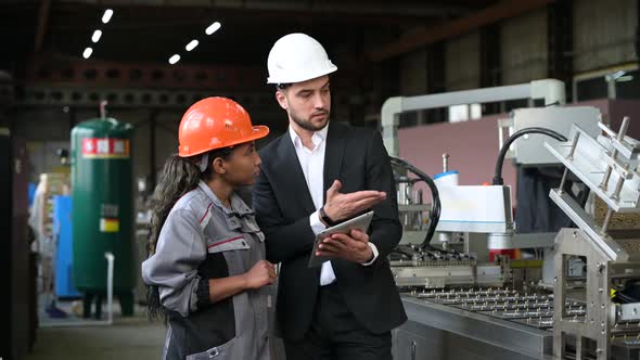 A young leader of the conveyor belt discusses work processes with a female worker