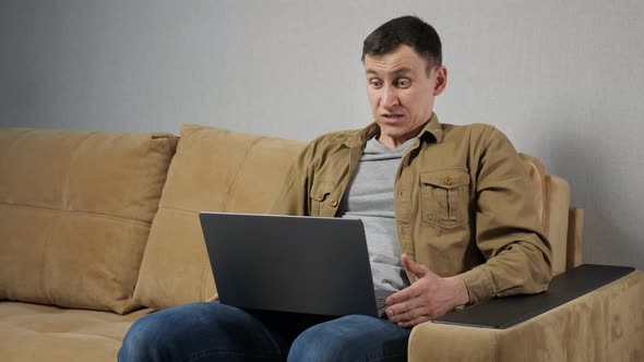 Man Plays Gambling Games on Computer Sitting on Couch