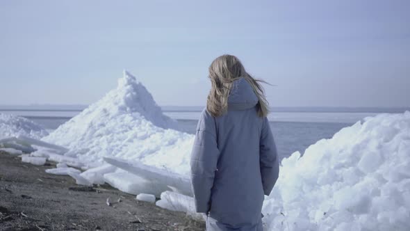 Young Woman in Warm Jacket Walking on the Glacier