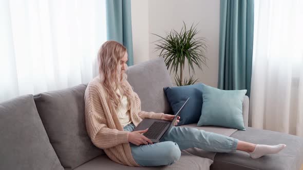Blonde Girl on the Couch with a Laptop Remote Work From Home Freelancer