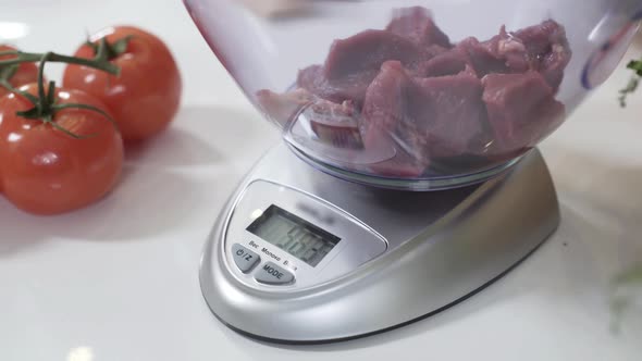 Pile of Chopped Meat on Electronic Scale in Kitchen. Standing on Flat Weighing Platform. Electronic