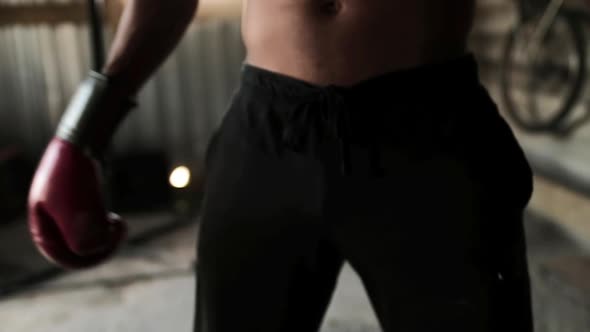 Boxer wearing boxing gloves flexing in the gym