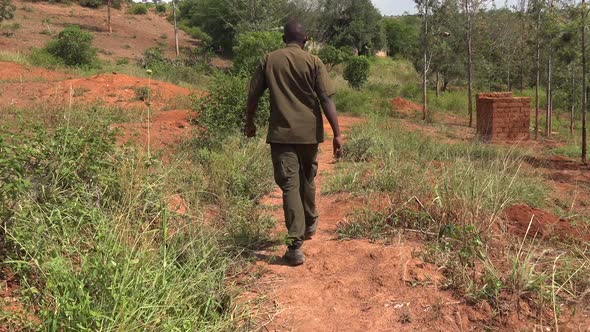 Black Man in Green Clothes Walks in Africa Nature