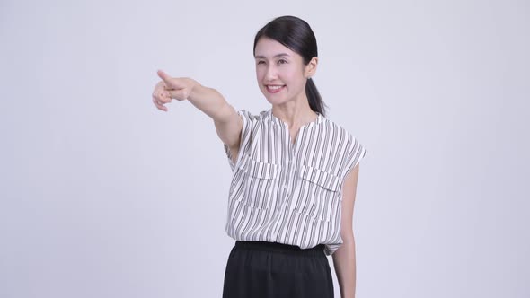Happy Beautiful Asian Businesswoman Directing and Pointing Finger