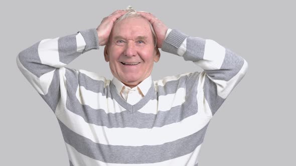 Delighted Senior Man on Grey Background