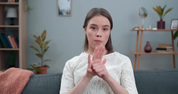 Crop View of Girl Showing with Deaf-mute Sign Language Stop Animal Abuse While Sitting on Sofa