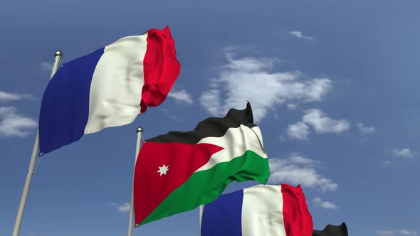 Waving Flags of Jordan and France on Sky Background