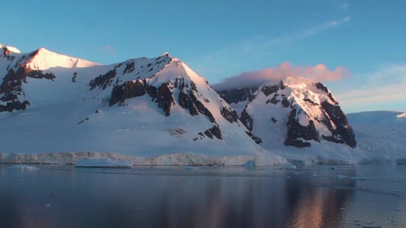 Sunset in Antarctica, with calm sea water.