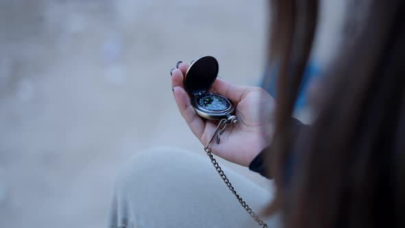 Close View of Young Woman’s Hand Using Metal Compass and Closing It